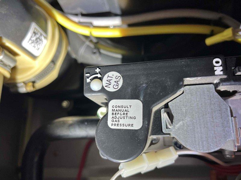Responded to no heat call on natural gas furnace installed in December 2020. Upon arrival, verified unit was not igniting despite homeowner replacing air filter prior to service call. Performed diagnostic inspection of gas furnace components including gas valve assembly, ignition system, and electrical connections. Inspected gas valve control module with ON/OFF markings and verified proper gas supply to unit. Examined all wire connections including red, beige, green, blue, and yellow control wiring to gas valve and associated components. Checked electrical connections at wire harness and verified secure terminations. Inspected burner assembly and heat exchanger components for proper operation. Documented equipment condition with detailed photographs of gas valve assembly showing natural gas designation and pressure adjustment warnings per manufacturer specifications. Verified all safety controls and limit switches. System restored to full operational status with proper ignition sequenc
