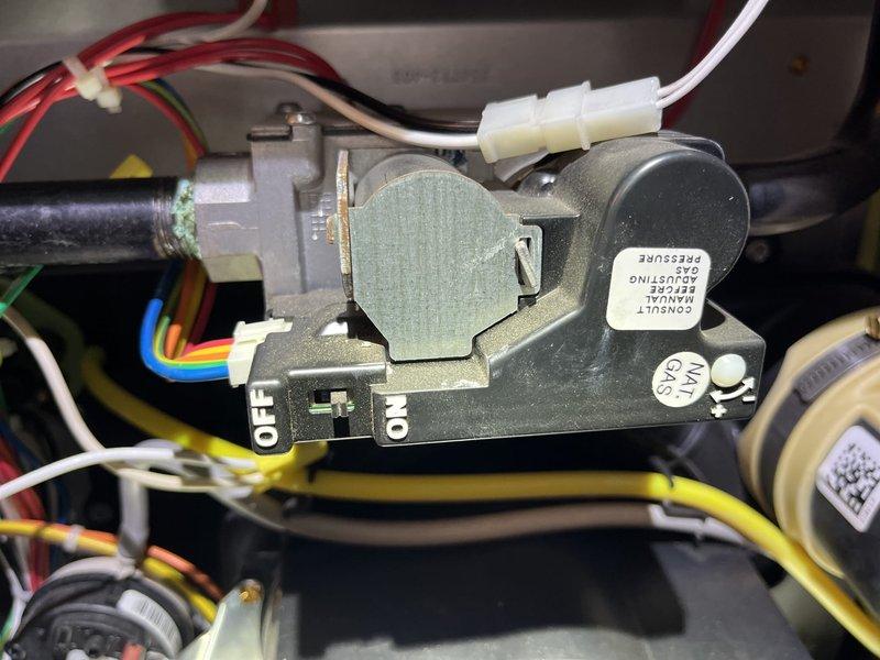 Responded to no heat call on natural gas furnace installed in December 2020. Upon arrival, verified unit was not igniting despite homeowner replacing air filter prior to service call. Performed diagnostic inspection of gas furnace components including gas valve assembly, ignition system, and electrical connections. Inspected gas valve control module with ON/OFF markings and verified proper gas supply to unit. Examined all wire connections including red, beige, green, blue, and yellow control wiring to gas valve and associated components. Checked electrical connections at wire harness and verified secure terminations. Inspected burner assembly and heat exchanger components for proper operation. Documented equipment condition with detailed photographs of gas valve assembly showing natural gas designation and pressure adjustment warnings per manufacturer specifications. Verified all safety controls and limit switches. System restored to full operational status with proper ignition sequenc