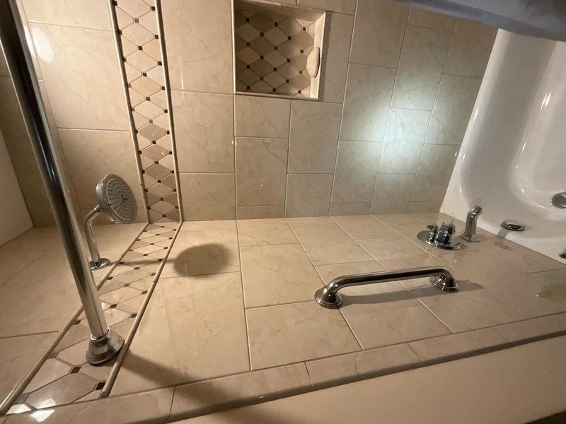 Completed comprehensive plumbing inspection of residential bathroom facilities including evaluation of vanity sink plumbing connections, supply lines, shut-off valves, P-trap assembly, bathtub fixtures, shower enclosure, and all visible chrome hardware. All plumbing components were inspected for proper operation, leaks, and general condition, with photographic documentation captured for service records.