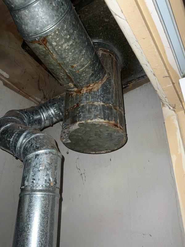 Responded to after-hours call for non-operational furnace less than one year old. Upon arrival, conducted comprehensive system inspection including visual assessment of ductwork and heating equipment. Performed carbon monoxide safety testing at water heater and heating system components, with readings within safe parameters (5 ppm). Documented existing conditions including significant rust corrosion at galvanized ductwork connection points and seams, particularly at horizontal-to-vertical duct junction. Noted weathered galvanized coating and moisture damage indicators throughout duct system. Inspected water heater installation area, copper piping connections, and associated mechanical components. Equipment remains under warranty coverage for potential repair costs.