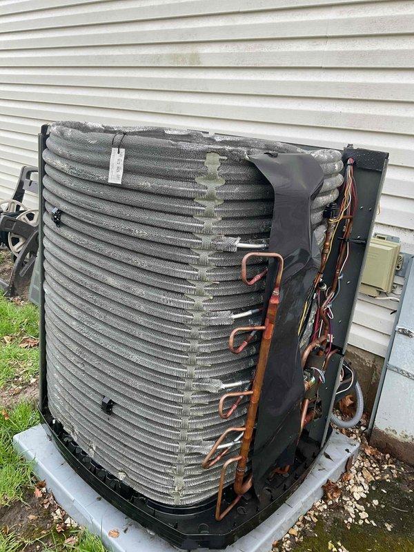 Completed BFMA preventive maintenance tune-up on outdoor air conditioning condenser unit. Removed side panel to access internal components and performed comprehensive inspection of refrigeration system including copper refrigerant lines, U-bend connections, and condenser coil assembly. Inspected condenser coil fins for debris accumulation and outdoor weathering, noting dirt buildup consistent with normal operation. Checked electrical connections and wiring throughout unit. Verified unit positioning on concrete pad with proper drainage via surrounding gravel base. All components found to be operational with routine wear patterns observed on exterior fins and coil assembly.