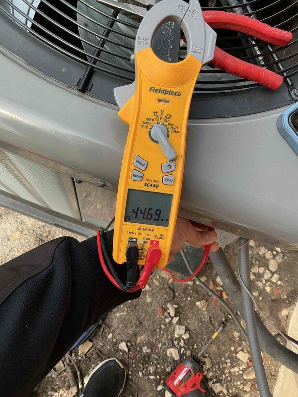 Performed comprehensive air conditioning tune-up service during afternoon appointment. Conducted electrical diagnostics on outdoor condenser unit using clamp meter, recording amperage readings of 44.69 amps to verify proper compressor and fan motor operation. Completed standard maintenance protocol including system inspection, performance testing, and documentation of equipment age for service records.