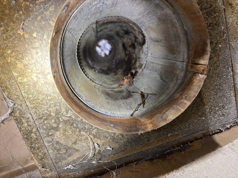 Completed residential tanked water heater installation with galvanized pipe connections. Installed BFRG140T6N unit with new flue system including 7x5x4 wye tee, 5x4 reducer, and 4x3 reducer to accommodate proper venting configuration. Added expansion tank to system for thermal expansion protection and code compliance. Addressed existing corroded floor drain fixture showing significant rust staining and deterioration. All components properly secured and tested for functionality upon completion.