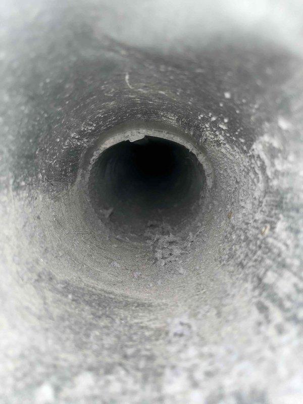 Completed dryer vent cleaning service during late morning appointment. Upon inspection, the vent duct interior showed significant accumulation of lint, dust, and debris coating the metallic walls, which posed a potential fire hazard and reduced airflow efficiency. Thoroughly cleaned the entire dryer vent system using professional rotary brush equipment, removing all built-up particulate matter from the ductwork to restore proper ventilation and ensure safe operation of the dryer appliance.