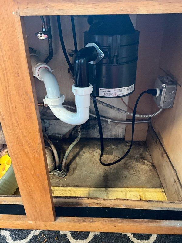 Responded to kitchen sink drainage issue affecting double-basin sink connected to garbage disposal unit. Upon inspection, accessed cabinet area beneath sink and assessed P-trap configuration and disposal connections. Cleared obstruction from drainage system, verified proper water flow through both basins and disposal unit, and tested all plumbing connections for leaks. System restored to full operational capacity with water draining freely through disposal and drain lines.