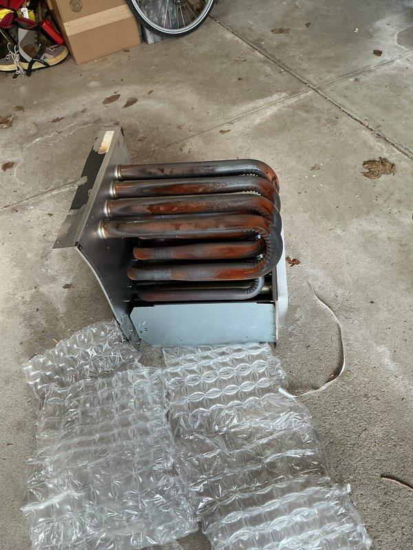 Replaced heavily corroded heat exchanger unit due to extensive oxidation and rust buildup on the serpentine coil assembly. The old component was removed, staged at headquarters for proper disposal, and documented with photographic evidence showing the deteriorated condition of the metallic tubing and housing.