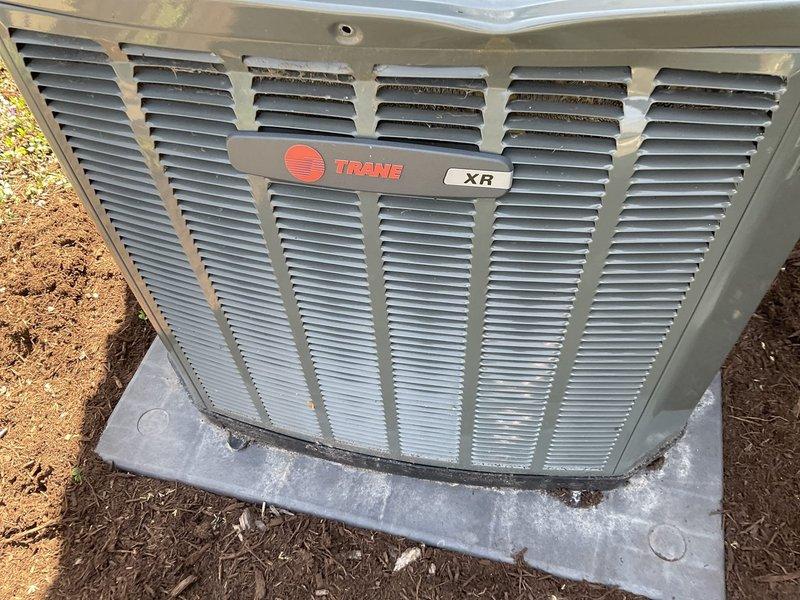 # BFMA Tune Up - Dual AC System Maintenance

Completed comprehensive BFMA tune-up service on two residential air conditioning systems, ages 7 and 11 years. Performed maintenance on Trane XR model outdoor condenser unit, which showed moderate exterior soiling and weathering consistent with age. Removed top cover to access internal components and inspected cylindrical condenser coil assembly, which exhibited heavy accumulation of dirt, dust, and debris between fins throughout the coil surfaces.

Cleaned condenser coils to remove environmental contaminants and restore proper airflow through fin spaces. Performed standard tune-up procedures including electrical connection inspection, refrigerant level verification, capacitor testing, and operational testing of both systems. Verified proper amperage draw on compressor and fan motor. Checked thermostat calibration and system cycling. Both units returned to normal operating parameters following maintenance procedures.

Documented equipment co