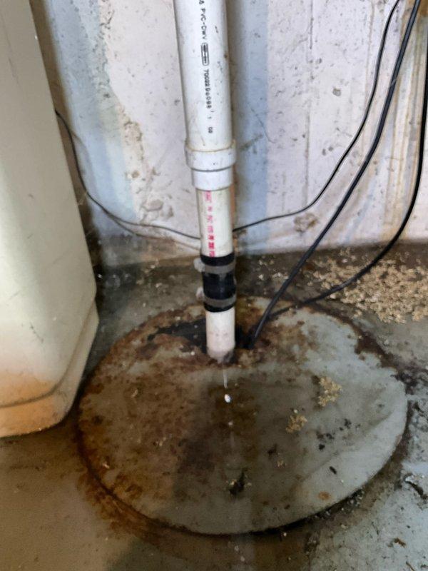 Responded to service call for failed sump pump with active water leakage in basement utility area. Upon inspection, found existing pump inoperable with evidence of chronic water seepage indicated by extensive rust staining and mineral deposits radiating across concrete floor from basin location. Removed and disposed of failed unit. Installed new 3/4 horsepower sump pump to provide increased pumping capacity and improved reliability. Verified proper operation of discharge line through existing white PVC piping system. Tested pump activation and cycling to ensure proper float switch function and adequate water removal. Applied military discount as requested. System operational upon completion with enhanced pumping performance.