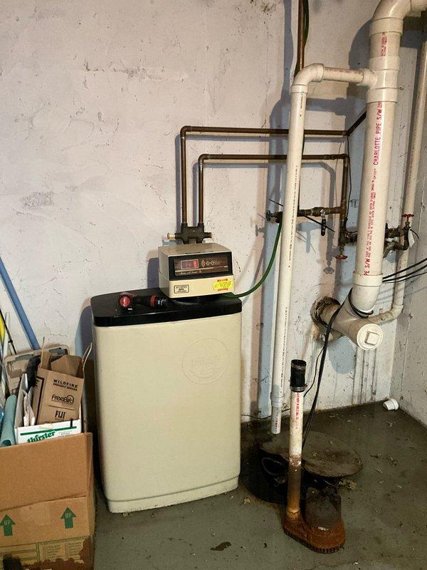 Responded to service call for failed sump pump with active water leakage in basement utility area. Upon inspection, found existing pump inoperable with evidence of chronic water seepage indicated by extensive rust staining and mineral deposits radiating across concrete floor from basin location. Removed and disposed of failed unit. Installed new 3/4 horsepower sump pump to provide increased pumping capacity and improved reliability. Verified proper operation of discharge line through existing white PVC piping system. Tested pump activation and cycling to ensure proper float switch function and adequate water removal. Applied military discount as requested. System operational upon completion with enhanced pumping performance.