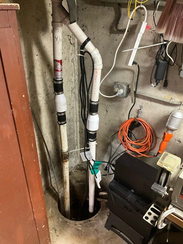 Responded to a sump pump failure in a basement utility area. Replaced the failed sump pump system, including new discharge piping and electrical connections. Verified proper operation of the new pump, tested float switch functionality, and ensured adequate drainage through the existing PVC discharge lines that run vertically along the foundation wall to the exterior discharge point.