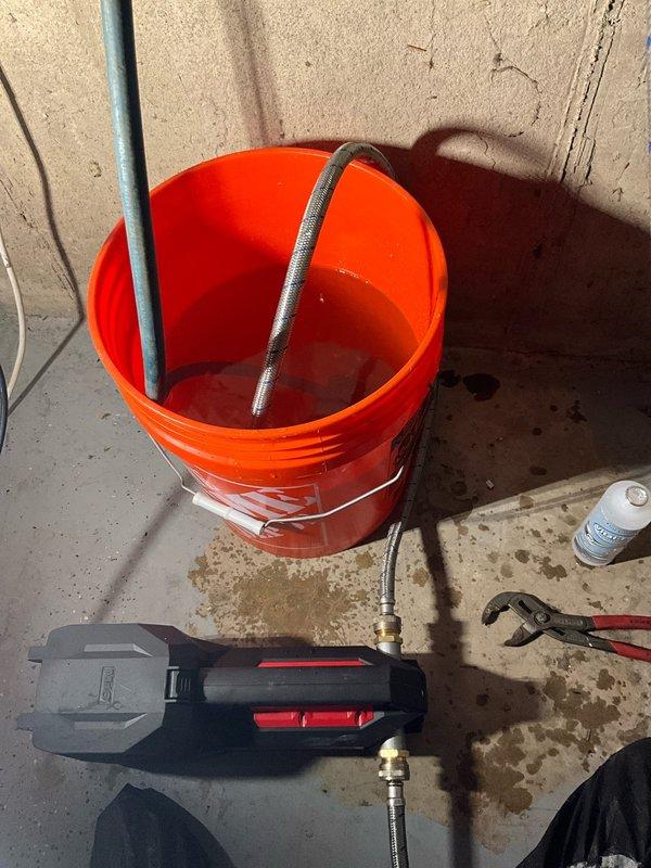 Performed comprehensive tankless water heater flush and tune-up on unit aged 10-12+ years. Isolated unit using service valves, connected flushing pump and hoses to inlet and outlet ports, and circulated descaling solution through heat exchanger to remove mineral buildup and scale deposits. Verified proper drainage, reconnected all plumbing connections, and restored unit to normal operation with improved efficiency.