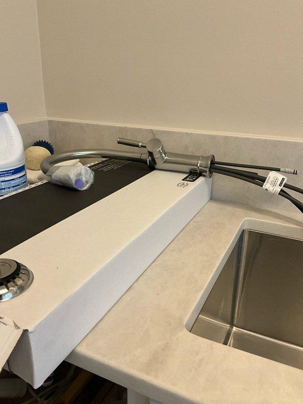 Successfully reconnected kitchen sink, dishwasher, and garbage disposal plumbing connections under cabinet. Installed and secured water supply lines and drain hoses for all fixtures, ensuring proper fit and leak-free operation of the undermount stainless steel sink with modern single-lever faucet assembly.