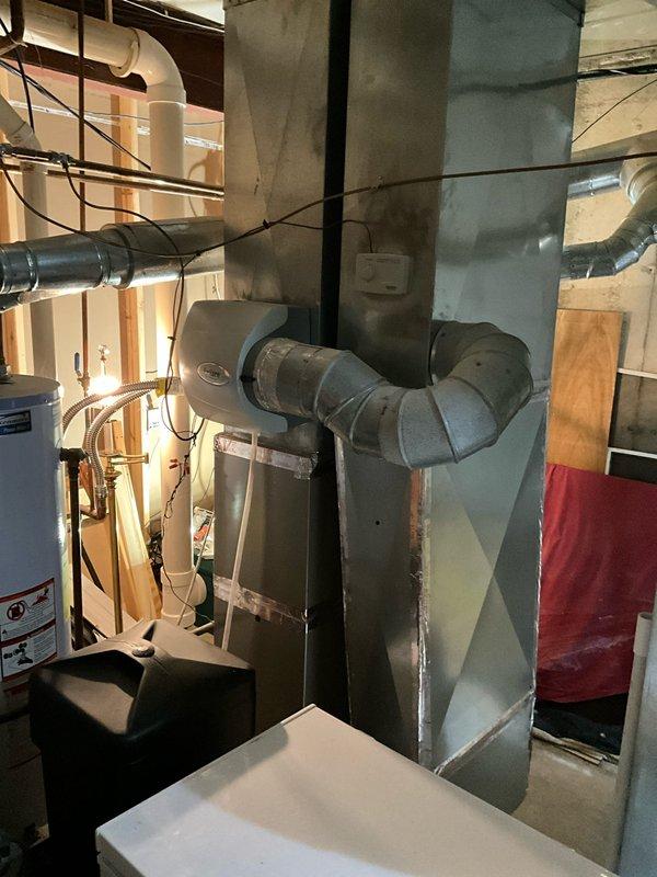 Completed comprehensive AC tune-up maintenance on two air conditioning systems at residential property. Performed standard preventive maintenance procedures including inspection of blower assembly, which showed moderate dust accumulation on squirrel cage fan blades. Accessed equipment in basement mechanical room where air handler and ductwork are located alongside water heater and associated plumbing systems. Inspected flexible duct connections, sheet metal ductwork, and overall system components. Coordinated arrival time with occupant requiring 30-minute advance notice. Documented equipment age for service records as it was previously unknown. Captured photographic documentation of mechanical room layout, HVAC equipment configuration, and blower wheel condition for maintenance files. All systems operational upon completion of tune-up procedures.