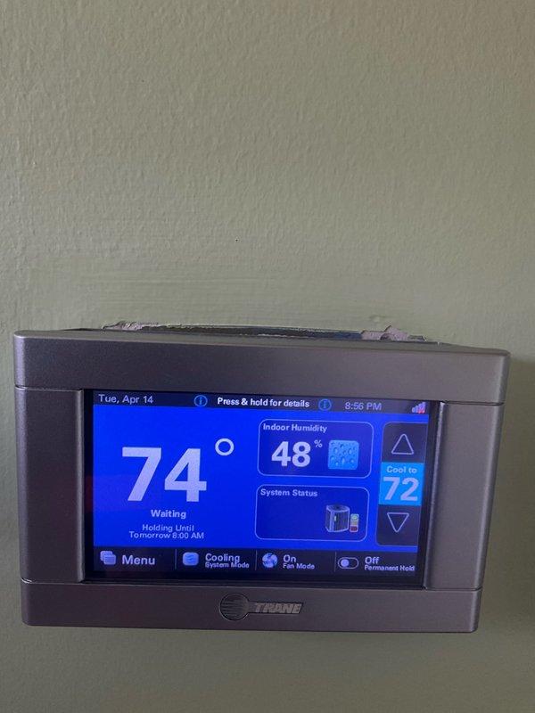 Completed comprehensive AC tune-up on 6+ year old system, coordinating arrival time with homeowner's work schedule for afternoon service. Performed thorough cleaning of heavily clogged outdoor condenser unit, which had extensive debris accumulation completely obscuring coil fins and significantly restricting airflow; removed layers of dirt, dust, and environmental buildup from all coil surfaces to restore proper heat transfer efficiency. Verified Trane thermostat operation showing system in cooling mode set to 72°F with indoor humidity at 48%, confirmed proper communication between thermostat and equipment, and ensured all system components functioning correctly following maintenance procedures.