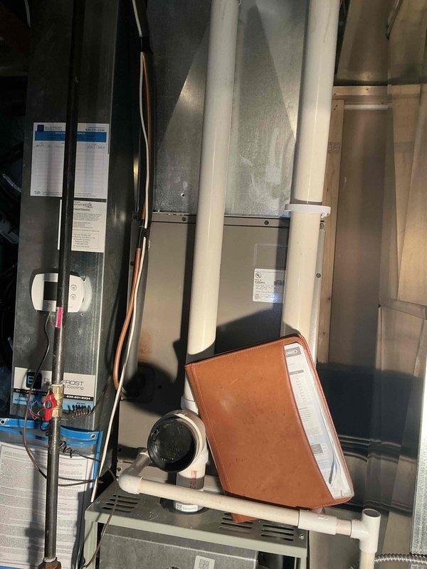 Performed comprehensive evaluation of failed upstairs outdoor AC compressor unit and indoor evaporator coil system. Documented existing equipment conditions including weathered outdoor condensing unit with visible corrosion on electrical disconnect panel and complete HVAC system configuration in mechanical room showing furnace, ductwork, refrigerant lines, and associated components. Provided detailed replacement estimate for new matched air conditioning system including outdoor condensing unit and indoor evaporator coil to restore cooling capacity to upper level of residence.