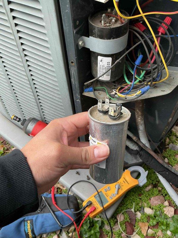 Responded to no cooling call at residential property. Upon inspection, diagnosed failed dual run capacitor as cause of system failure. Tested capacitor with digital multimeter, confirming it was out of specification and preventing compressor and condenser fan motor operation. Removed defective capacitor and installed replacement unit, restoring proper electrical function to outdoor condensing unit. Verified system startup, confirmed compressor and fan motor operation, and tested overall cooling performance. Unit operating within normal parameters upon completion.