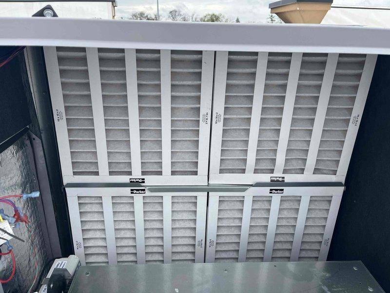 Completed scheduled BFMA preventive maintenance on commercial rooftop unit including comprehensive tune-up and filter replacement. Replaced four pleated air filters in the 2x2 grid configuration within the RTU's filter compartment, ensuring proper airflow and filtration efficiency. Performed standard AC service inspection of the rooftop unit, verifying operational status of condenser coils, refrigerant pressures, electrical components, and disconnect box. All filters were properly secured in mounting framework, unit tested and confirmed operational upon completion.