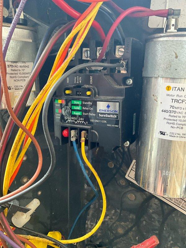 Completed comprehensive air conditioning tune-up on 12+ year old system, including inspection of all electrical components, control panel, Emerson SureSwitch relay module, and Titan motor run capacitor rated at 70 MFD 440/370V. Inspected blower motor assembly, verified all wire connections and terminals, checked ground connections, and documented system condition with photos of control panel and motor wiring assembly.