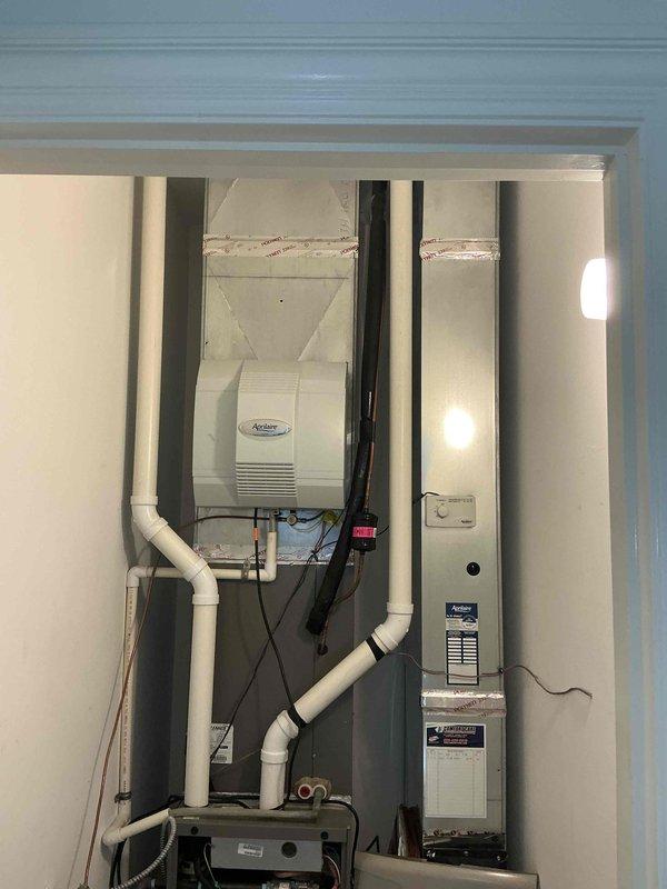 Provided estimate for replacement of second-floor air conditioning system in a two-zone residential HVAC setup with dual furnaces and AC units. Inspected existing equipment including air handler unit mounted in interior mechanical closet with associated ductwork and PVC condensate piping, as well as outdoor condenser units positioned on concrete pads against exterior wall with refrigerant lines running to interior components.