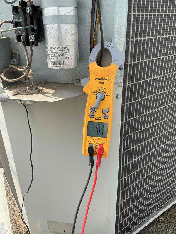 Completed commercial BFMA preventive maintenance tune-up on 11-year-old rooftop air conditioning unit accessed through dock area. Performed comprehensive system diagnostics including electrical testing of capacitor, contactor, and control components with digital multimeter, recording voltage readings of 437V and amperage draw of 14.92A to verify proper operation. Inspected condenser coil condition, electrical connections, and all major components to ensure optimal system performance and reliability for continued operation.