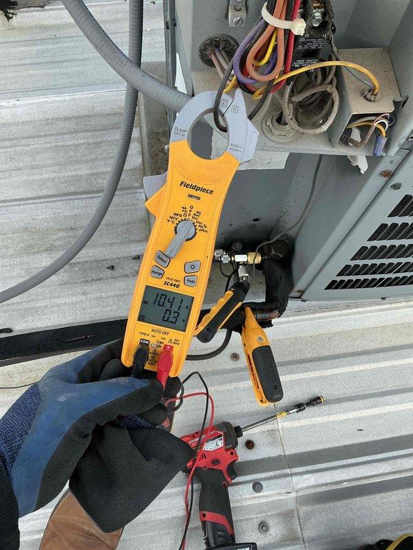 Completed commercial BFMA tune-up service on rooftop AC unit 5, a 10-year-old system. Performed comprehensive preventive maintenance including electrical diagnostics using clamp meter, recording amp draw and voltage readings to verify proper compressor operation. Inspected condenser coil fins, refrigerant line connections, and overall unit condition, confirming equipment is operating within normal parameters for continued reliable service.