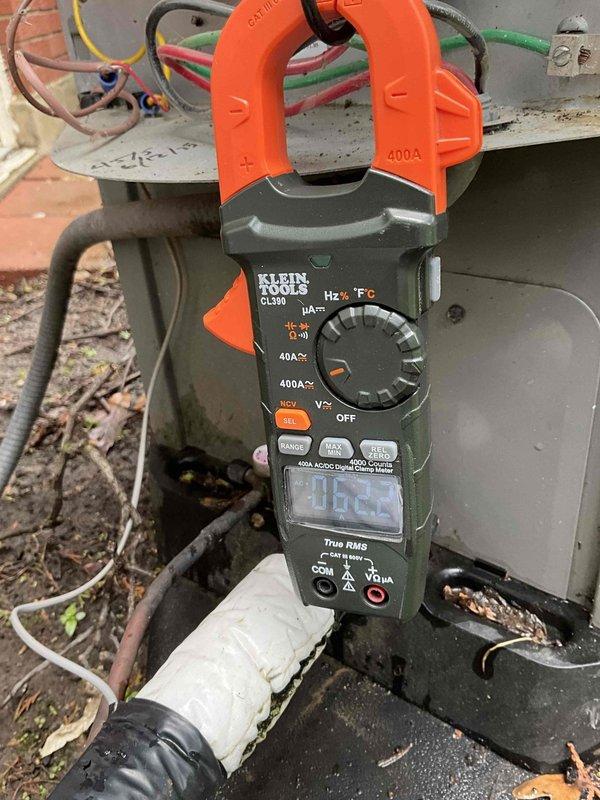 Completed spring preventative maintenance tune-up on outdoor condensing unit. Removed top access panel and inspected internal components including compressor and electrical connections. Measured electrical parameters using clamp meter, recording amp draw of 1.23A. Noted significant dirt and debris accumulation on condenser coils and exterior surfaces requiring cleaning attention. Verified unit operational status and confirmed all mechanical components functioning properly during inspection.