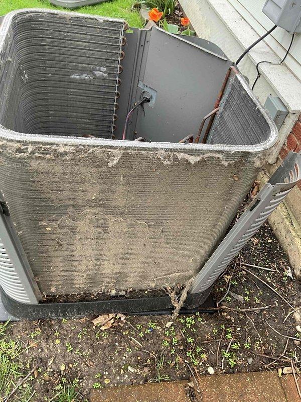 Completed spring preventative maintenance tune-up on outdoor condensing unit. Removed top access panel and inspected internal components including compressor and electrical connections. Measured electrical parameters using clamp meter, recording amp draw of 1.23A. Noted significant dirt and debris accumulation on condenser coils and exterior surfaces requiring cleaning attention. Verified unit operational status and confirmed all mechanical components functioning properly during inspection.