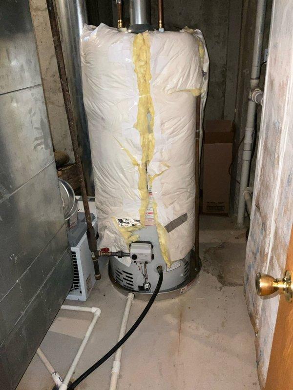 Responded to service call for recently installed tanked water heater experiencing leaking and complete loss of hot water. Upon arrival, performed comprehensive inspection of unit installed in September. Identified active leak at base of water heater with visible water accumulation in drip pan showing rust and corrosion. Inspected all plumbing connections including copper supply lines and fittings at top of unit, examining for loose connections or failed seals. Evaluated gas control valve, burner assembly, and electrical connections at base of tank. Assessed temperature and pressure relief valve for proper operation and signs of discharge. Documented condition of installation including insulation wrap, securing tape, and overall system configuration. Photographed leak source, drip pan condition, and mechanical components for warranty evaluation. Determined unit failure likely due to internal tank defect given recent installation date. Provided customer with findings and recommendations 
