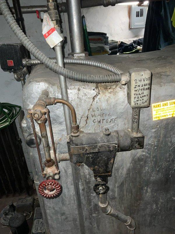 Conducted on-site assessment of existing boiler system for replacement estimate. Evaluated aged heating unit with low water cut-off control, noting significant deterioration, rust accumulation, and outdated components throughout the system. Documented current equipment configuration including piping layout, electrical connections, and basement installation conditions to provide comprehensive replacement proposal based on reference installation specifications.