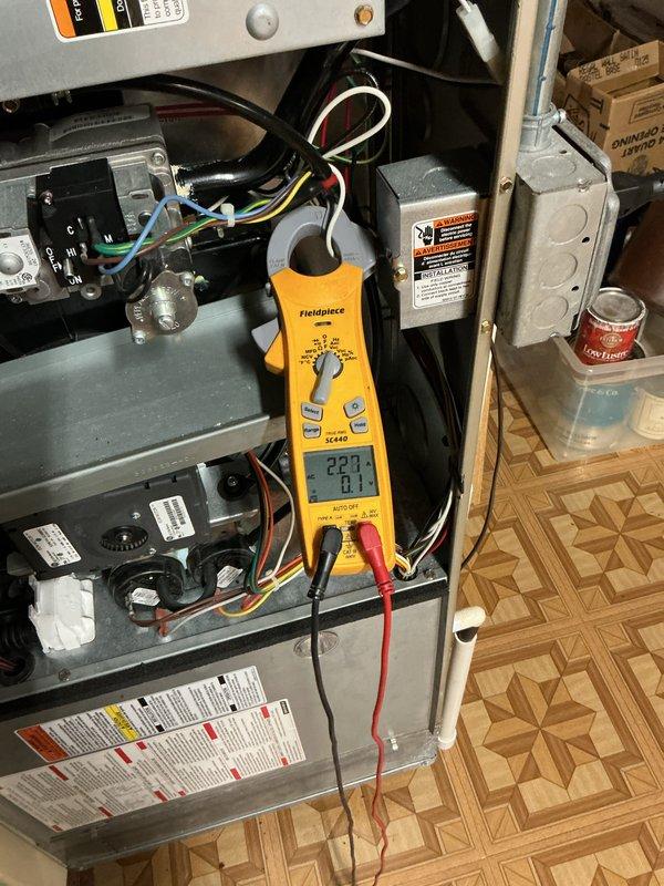 Completed comprehensive BFMA tune-up service on 18+ year old Carrier split system air conditioning unit. Performed electrical diagnostics on indoor air handler using digital multimeter, verifying amperage draws, voltage levels, and control board functionality. Inspected outdoor condenser unit, noting age-related weathering and surface discoloration on cabinet and coil assembly. Both indoor and outdoor components operational at time of service completion.