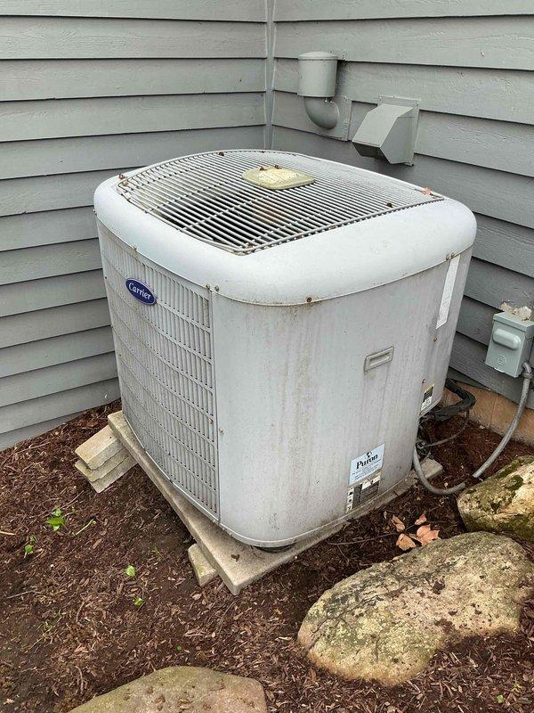 Completed comprehensive BFMA tune-up service on 18+ year old Carrier split system air conditioning unit. Performed electrical diagnostics on indoor air handler using digital multimeter, verifying amperage draws, voltage levels, and control board functionality. Inspected outdoor condenser unit, noting age-related weathering and surface discoloration on cabinet and coil assembly. Both indoor and outdoor components operational at time of service completion.