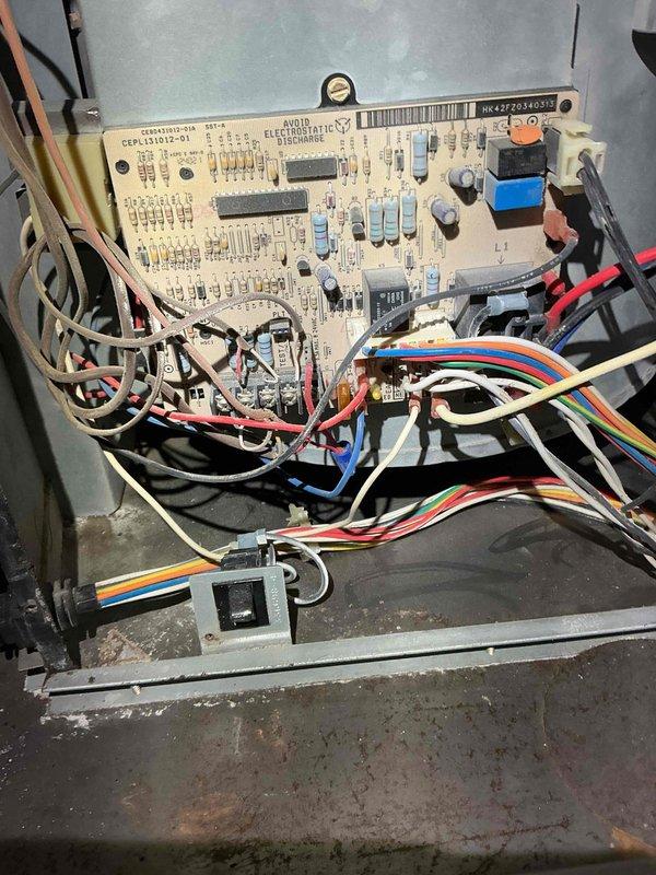 Responded to after hours service call for HVAC system malfunction. Upon inspection, accessed control cabinet and circuit board assembly to diagnose system failure. Examined internal components including printed circuit board with visible capacitors, resistors, and integrated circuits. Inspected electrical connections and wire harnesses for loose connections or damage. Checked control board mounting and terminal connections. Identified dust and debris accumulation within cabinet that required attention. Performed diagnostic assessment of control system components and wiring configuration to determine cause of system shutdown.