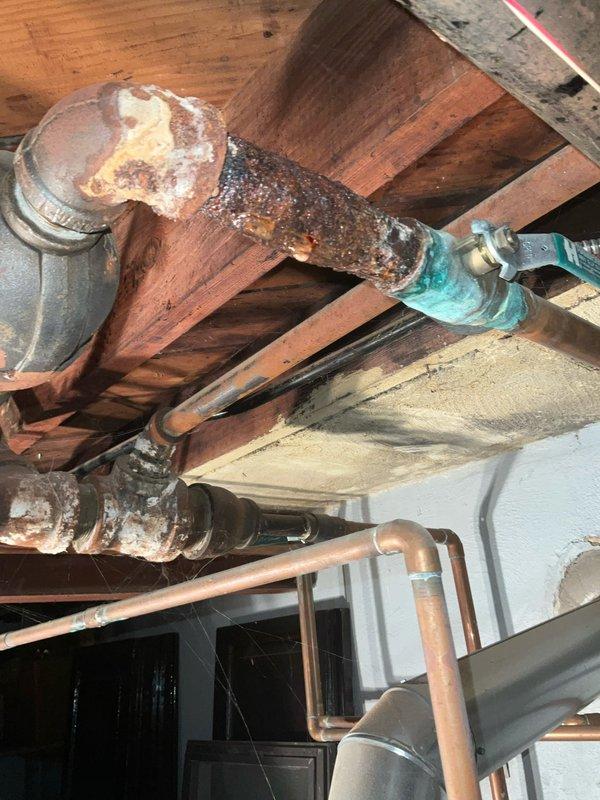 Responded to service call for Buderus G124X-25 II boiler with electronic malfunction caused by water intrusion from leaking overhead copper piping. Diagnosed severely corroded copper supply line above boiler that had been actively leaking onto unit's control board and electrical components. Repaired deteriorated piping section and replaced corroded fittings to eliminate leak source. Dried and inspected boiler electronics, tested all safety controls, and verified proper system operation before restoring unit to service.