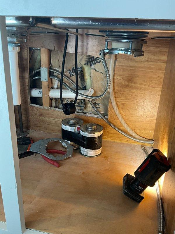 Completed installation of client-provided kitchen faucet and garbage disposal unit in double-basin undermount stainless steel sink. Supplied and installed new basket strainer assembly and two P-traps to ensure proper drainage configuration. All plumbing connections tested and verified leak-free, with one-year labor warranty provided on installation work performed.