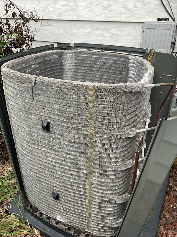 Completed comprehensive BFMA tune-up service on residential HVAC system, including AC unit and water heater inspection. Removed exterior panels to access outdoor condenser unit, revealing significant dirt accumulation and debris on condenser coil with visible discoloration and fin deterioration. Performed thorough cleaning of condenser coil to remove built-up contaminants, cleared surrounding area of leaves and debris, and conducted full system evaluation on equipment over three years old. All components inspected, system operational parameters verified, and unit reassembled with panels secured.