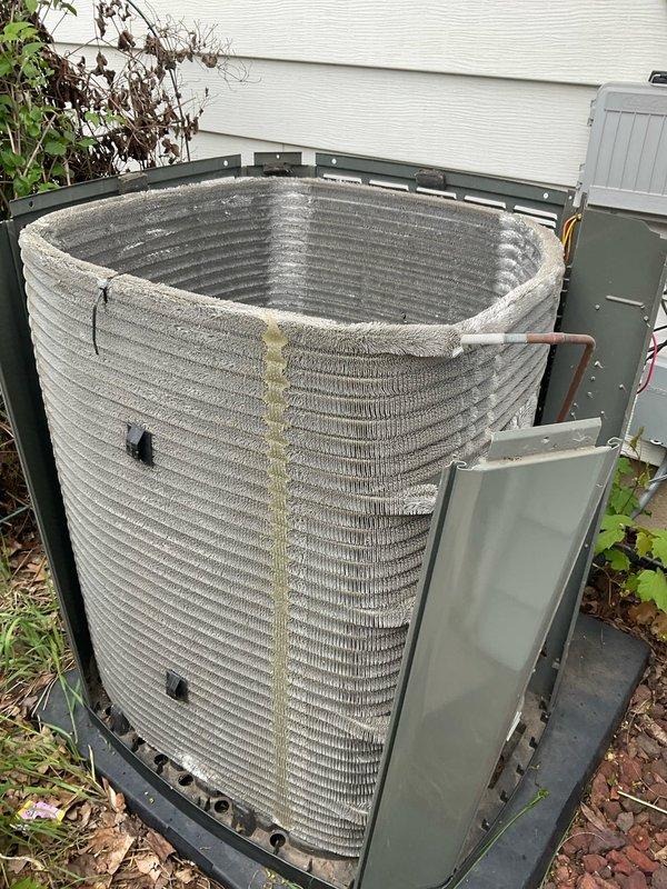 Completed comprehensive BFMA tune-up service on residential HVAC system, including AC unit and water heater inspection. Removed exterior panels to access outdoor condenser unit, revealing significant dirt accumulation and debris on condenser coil with visible discoloration and fin deterioration. Performed thorough cleaning of condenser coil to remove built-up contaminants, cleared surrounding area of leaves and debris, and conducted full system evaluation on equipment over three years old. All components inspected, system operational parameters verified, and unit reassembled with panels secured.