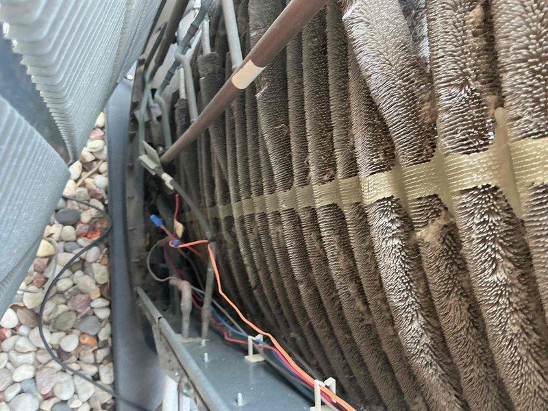 Completed comprehensive BFMA tune-up service on a 5+ year old air conditioning system during afternoon appointment window. Performed thorough inspection of outdoor condensing unit, including evaluation of finned coil heat exchanger which showed moderate dirt and debris accumulation between fins, evaporator coil assembly, copper refrigerant lines with service valves, fan blade assembly, electrical connections, and all associated components. System was found operational with normal wear patterns consistent with age and outdoor exposure; documented equipment condition with photographic records for maintenance history.