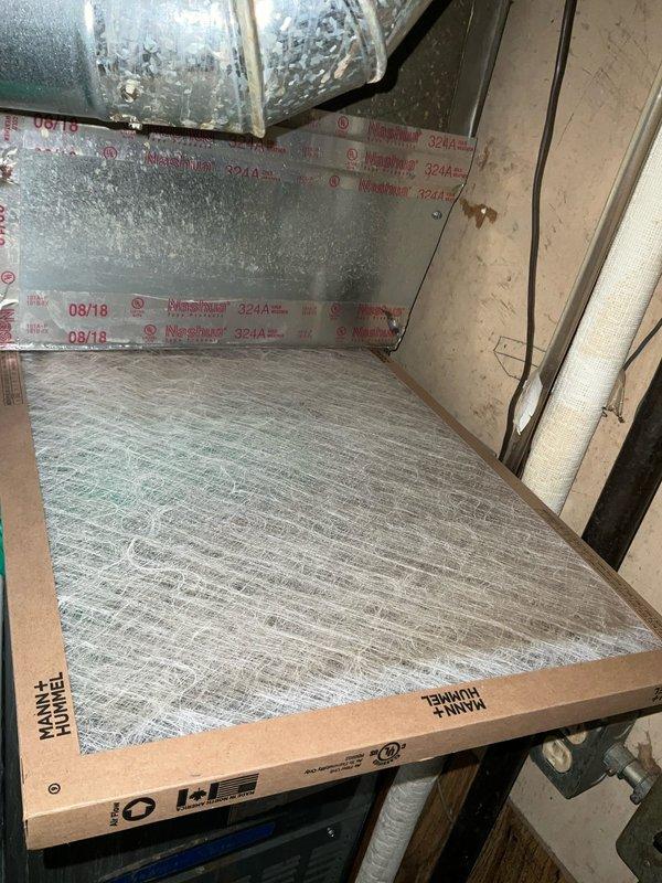 Completed comprehensive air conditioning tune-up on 7+ year old system during morning service window. Performed standard maintenance procedures including inspection of evaporator coil, which showed dust accumulation and vertical staining on return air grille requiring cleaning. Documented significant condensation on supply ductwork indicating proper cooling operation but potential insulation concerns in attic space where air handler is located. Inspected air filter condition and overall system components, verified proper airflow through return grille, and assessed ductwork integrity near foam insulation panels in mechanical area.