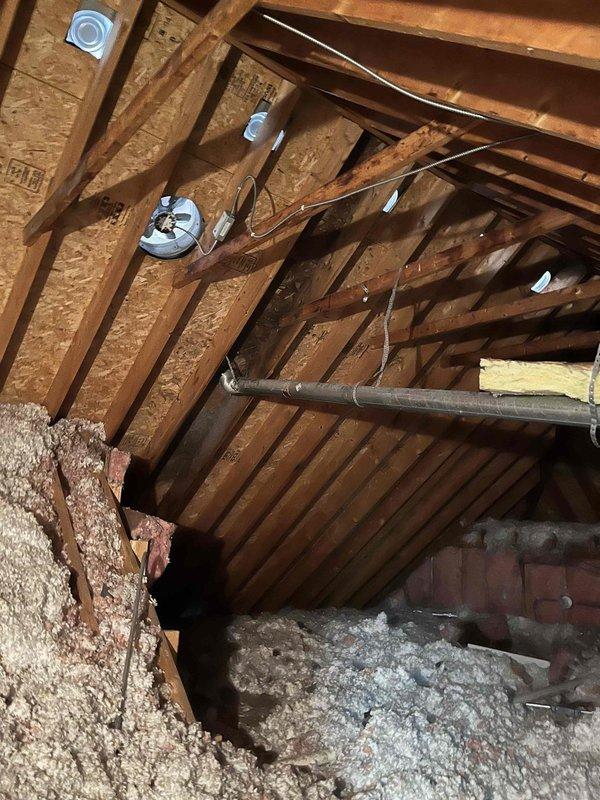 Responded to condensation issue in attic caused by disconnected dryer vent ductwork. Accessed attic space using 8-10ft ladder and placed boards across joists for safe navigation. Inspected existing flexible ductwork and located disconnection point where dryer vent required proper connection to roof stove pipe termination. Documented existing conditions showing flexible gray ribbed ductwork with previous repair attempts, surrounded by pink fiberglass insulation, and overall attic space with exposed roof trusses, electrical junction boxes, and blown-in loose-fill insulation on attic floor. Provided estimate for proper reconnection of dryer vent ductwork to eliminate moisture infiltration into roof assembly.
