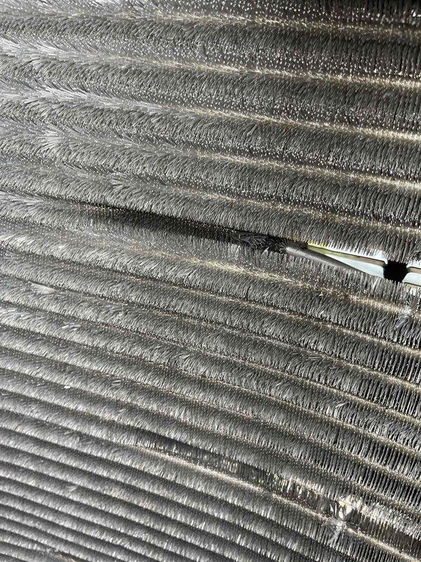 Completed comprehensive BFMA tune-up service on a 6-year-old air conditioning system during morning appointment window. Performed full system inspection including evaporator coil assessment, which showed moderate dust and debris accumulation between aluminum fins with some discoloration in upper sections. Inspected temperature sensor probe placement and verified proper positioning within coil assembly. Examined blower assembly and associated wiring connections, confirming all electrical components and color-coded wiring were secure and functioning properly. System operational and ready for cooling season.