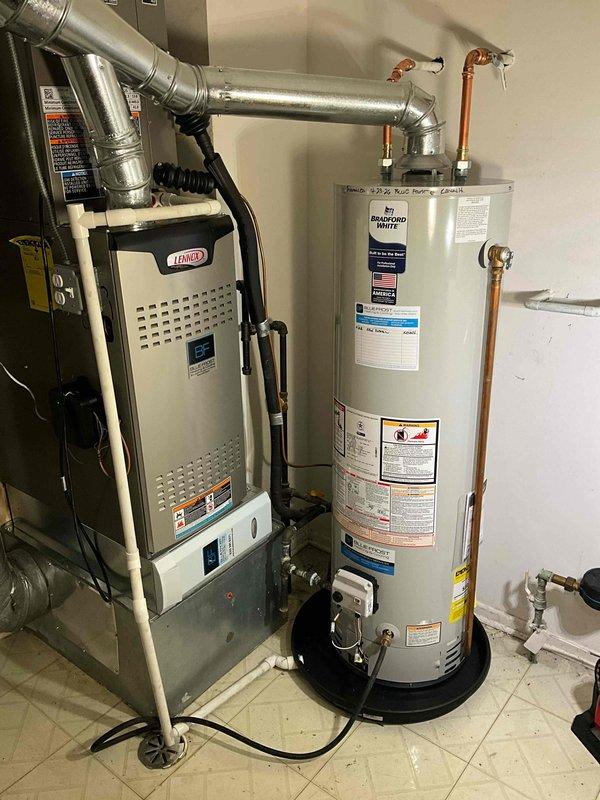 Installed a new 40-gallon Bradford White tanked water heater in the residential utility room adjacent to the existing Lennox furnace. Connected copper supply and discharge lines to the top of the unit, secured all piping with appropriate hangers and strapping, and positioned the water heater on a code-compliant base platform with proper clearances for ventilation and service access.