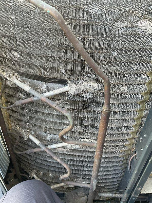 Completed comprehensive BFMA tune-up service on 10+ year old air conditioning system. Performed full inspection of outdoor condensing unit, including evaluation of cylindrical condenser coil assembly with concentric fin arrangement, verified refrigerant line connections and copper tubing integrity, and assessed coil cleanliness with noted dust accumulation between fins. Replaced 16x25x1 pleated air filter to ensure proper airflow and system efficiency.