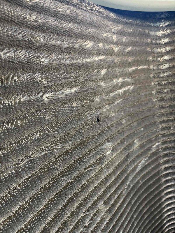 Completed comprehensive BFMA tune-up on 10-month-old AC system during early afternoon service window. Performed standard preventive maintenance inspection including filter evaluation and refrigerant line assessment. Documented significant frost accumulation on refrigerant lines indicating potential airflow restriction or refrigerant charge issue requiring further diagnosis. Air filter showed light dust accumulation consistent with normal usage. Captured photographic documentation of system condition for service records.