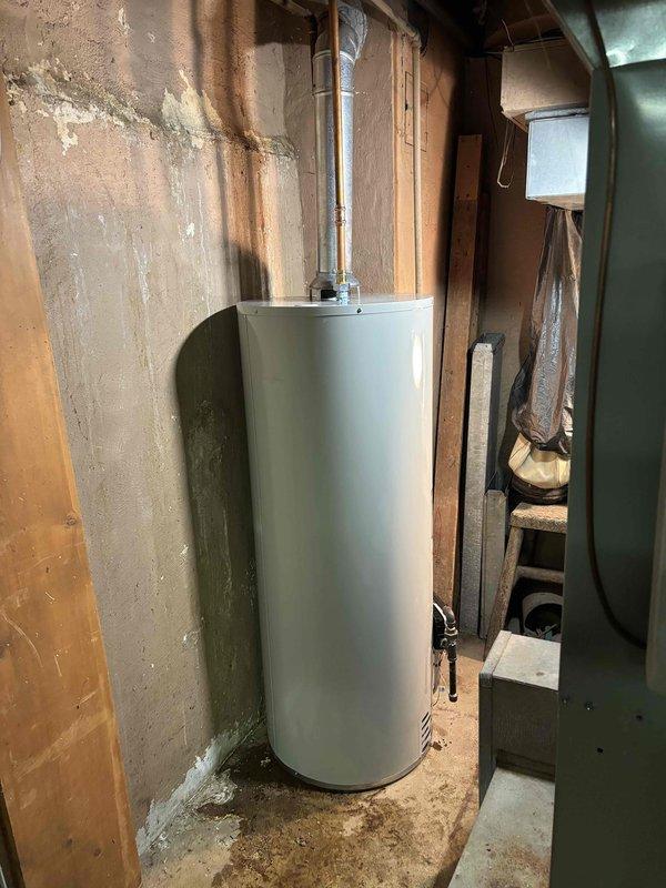 Removed and disposed of existing water heater from basement location. Installed new 50-gallon natural gas Bradford White water heater with 6-year tank warranty and 1-year parts and labor warranty. Modified and connected flue pipe, natural gas line, and water supply lines to ensure proper operation and code compliance.