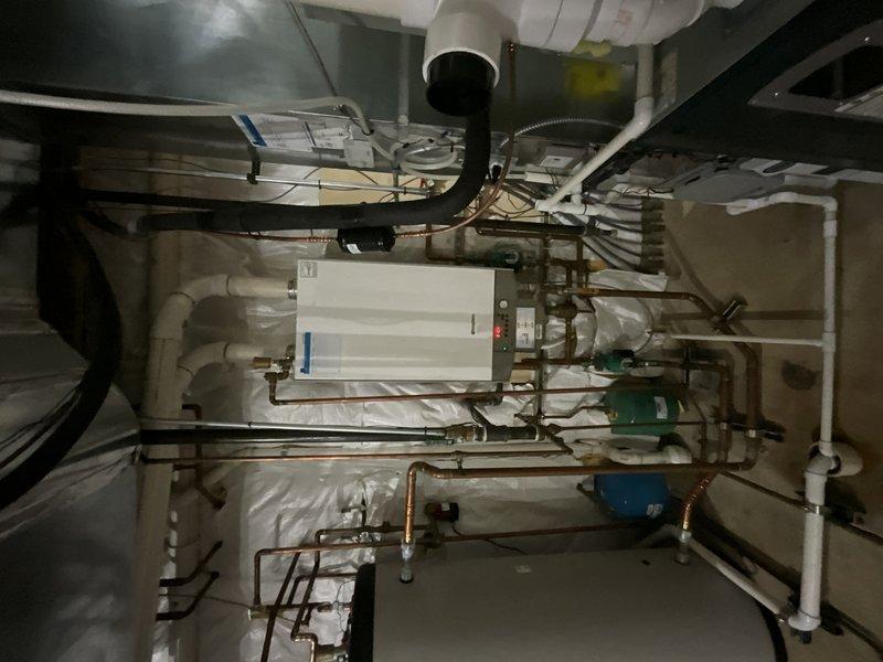 Completed full boiler replacement by installing a Navien NFB-175 unit with integrated manifold system and dehumidifier. Maintained existing zone control configuration while integrating new equipment with copper piping network, expansion tank, and PVC drainage systems. All connections, electrical components, and ventilation properly configured and tested for optimal system performance.