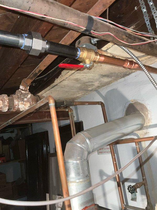 Responded to service call for boiler system with leaking piping and malfunctioning zone controller. Upon arrival, located active leak in copper piping connections within the mechanical room and assessed the existing zone control cabinet, which showed significant age-related deterioration with peeling paint and worn components. Retrieved necessary replacement parts from headquarters including new zone controller and plumbing fittings. Repaired leaking copper pipe connections using proper soldering techniques and installed replacement fittings where needed. Removed old zone controller from blue cabinet enclosure and installed new unit, reconnecting all electrical wiring, circuit breakers, and control mechanisms according to manufacturer specifications. Verified proper operation of ball valves, pressure gauges, and associated plumbing connections throughout the boiler system. Tested zone controller functionality to ensure proper communication with boiler and heating zones. System restored