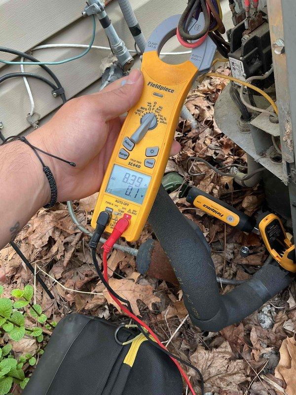 Completed comprehensive BFMA tune-up on 14+ year old air conditioning system in preparation for home sale. Performed standard AC maintenance protocol including inspection of outdoor condensing unit, refrigerant line assessment, and electrical system testing with clamp meter showing 24.1V readings. Addressed significant maintenance concern by cleaning heavily clogged condensate drain pan containing accumulated organic debris, dead leaves, and sludge buildup around pump assembly and copper discharge lines. System operational and ready for continued service.