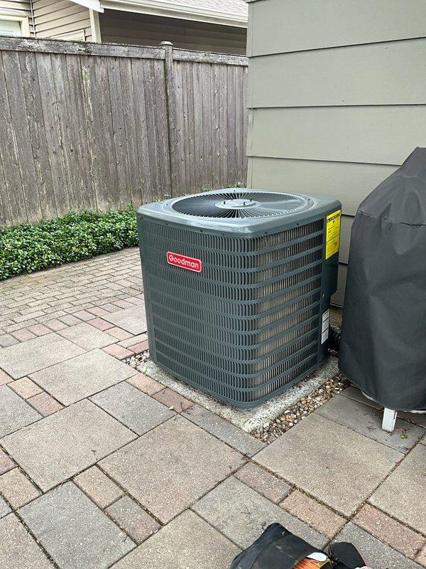 Completed comprehensive air conditioning tune-up on a 3-year-old Goodman condenser unit located on exterior paver patio. Performed full system inspection including visual assessment of unit housing, protective grille, and internal components, verified proper airflow through horizontal fin array, checked electrical connections and refrigerant lines, and confirmed unit operational integrity with no visible signs of damage, corrosion, or deterioration noted.