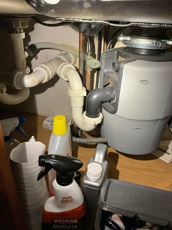 Completed comprehensive plumbing inspection as part of preventative maintenance tune-up service. Inspected kitchen sink plumbing system including P-trap configuration, garbage disposal unit, supply lines, and drain connections for proper operation and potential leaks. Evaluated bathroom sink fixture including aged brass faucet assembly, drain components, and associated hardware for functionality and wear. All accessible plumbing components were visually assessed and photographed for documentation purposes.