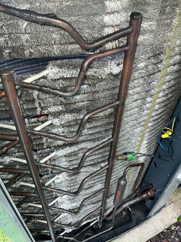 Completed comprehensive BFMA tune-up service on an 18-year-old Trane air conditioning system. Performed full system inspection of outdoor condenser unit and indoor evaporator coil assembly, verified refrigerant line connections and valve operations, and documented equipment condition through photographic records. All components found operating within normal parameters with system ready for continued seasonal use.